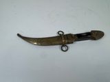 a close up of a small knife on a white surface
