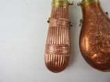 two copper vases sitting next to each other on a table