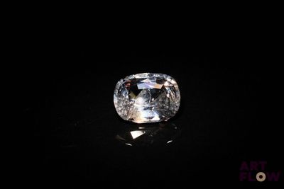 un diamant blanc sur une surface noire