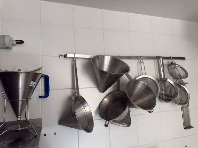 many pots and pans hanging on the wall in the kitchen