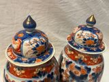 deux vases bleus et orange posés sur une surface blanche