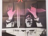 une vieille affiche de cinéma représentant une femme les mains levées en l'air
