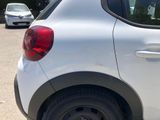 a small white car parked on the side of the road