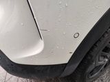 a close up of a car ' s front bumper with water droplets on it