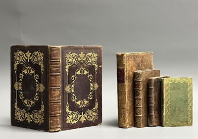 three old books sitting on top of each other next to each other