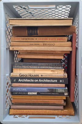 a stack of books sitting in a crate on top of a table