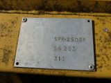 a close up of a metal plate on a yellow machine