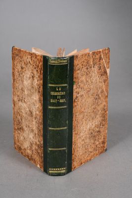an old book with a green cover on a table