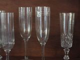 four wine glasses sitting on top of a wooden shelf