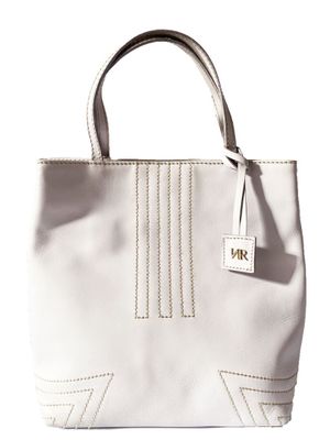 le sac à main blanc est posé sur une surface blanche et porte une étiquette