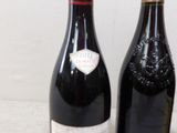 two bottles of wine are sitting next to each other on a counter