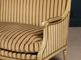 a striped couch sitting in a room with a black wall