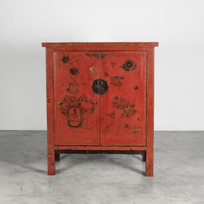 une vieille armoire rouge décorée de fleurs et d'oiseaux peints