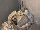 des toilettes situées dans un coin d'une pièce où il y a beaucoup d'objets par terre