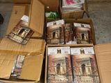 Plusieurs cartons remplis de livres sont posés par terre près d'un mur.