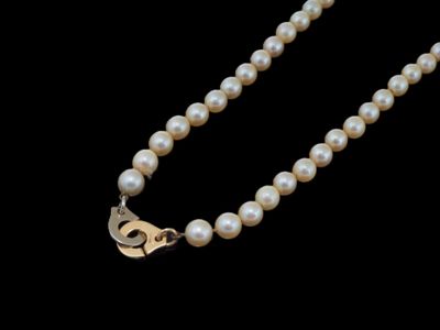 un gros plan d'un collier de perles sur fond noir