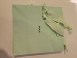 a small green bag with a bow on top of it