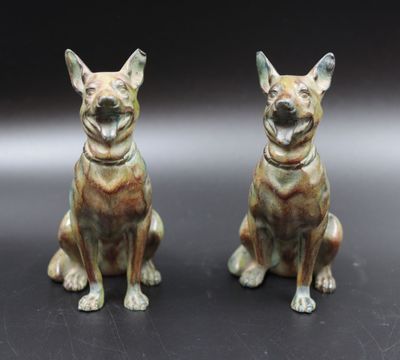 deux figurines de chiens assis l'une à côté de l'autre sur une table