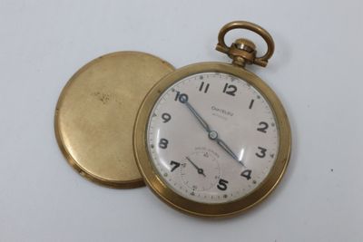 a gold pocket watch sitting on top of a white table