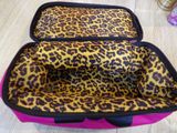 a close up of a leopard print bag on a wooden floor