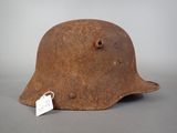 an old rusty helmet with a tag on it sitting on a table