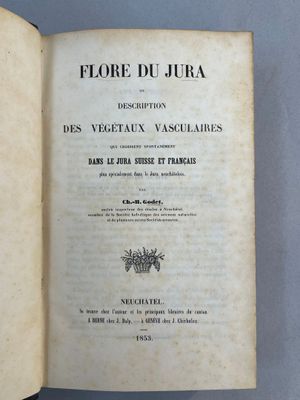 un livre ouvert posé sur une table, à côté d'une table bleue
