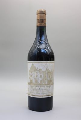 une vieille bouteille de vin posée sur une table blanche