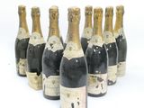 six bottles of champagne are lined up in a row on a white surface