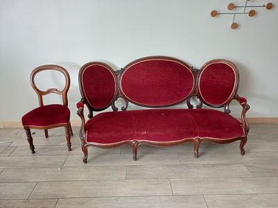 un canapé rouge et deux fauteuils dans une pièce