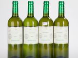 trois bouteilles de vin sont alignées sur une surface blanche