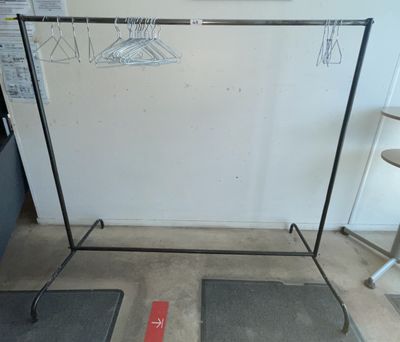 two mats on the floor next to a clothes rack