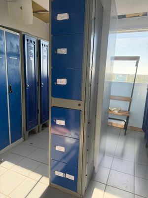 several blue lockers are lined up in a row in a hallway