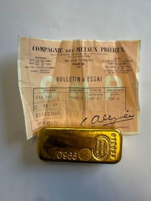 un lingot d'or posé sur une feuille de papier accompagnée d'un reçu