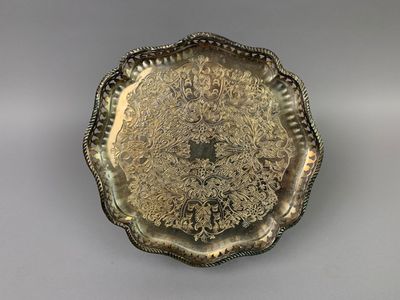 an antique silver plate with a floral design on it