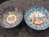 une paire d'assiettes colorées ornées de motifs, posées sur une table