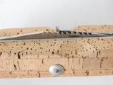 a cork and a cork opener on top of a piece of wood