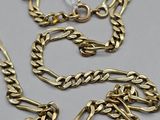 un gros plan sur un collier et un bracelet en chaîne d'or posés sur une table