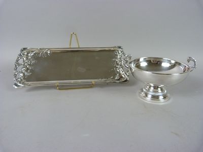 un plateau en argent orné d'un miroir et un bol en argent posé sur la table