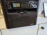 a printer sitting on top of a cabinet next to a picture frame