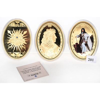 three gold coins with a picture of a woman and a man on them