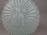 a glass vase with a statue on it on a table