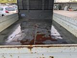 a dirty truck bed with rust on it in a parking lot