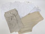 une chemise blanche et un pantalon beige posés sur une table blanche