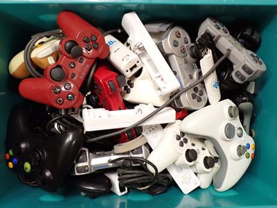 pile of video game controllers and controllers in a blue container