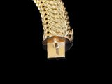 a close up of a gold chain bracelet on a black background