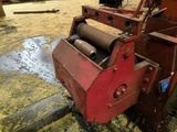 a red machine that is sitting in the dirt