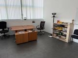 a room with a desk, chairs, and a whiteboard on the wall