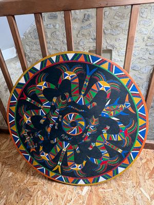 une assiette colorée posée sur une chaise en bois près d'un mur