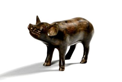 une statue représentant un cochon, posée sur une surface blanche