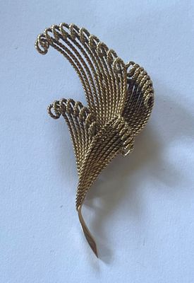 une broche dorée sur laquelle est représenté un oiseau